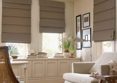Tan roman blinds in a lounge area.