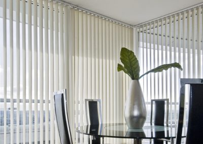 White vertical blinds in a dining area.