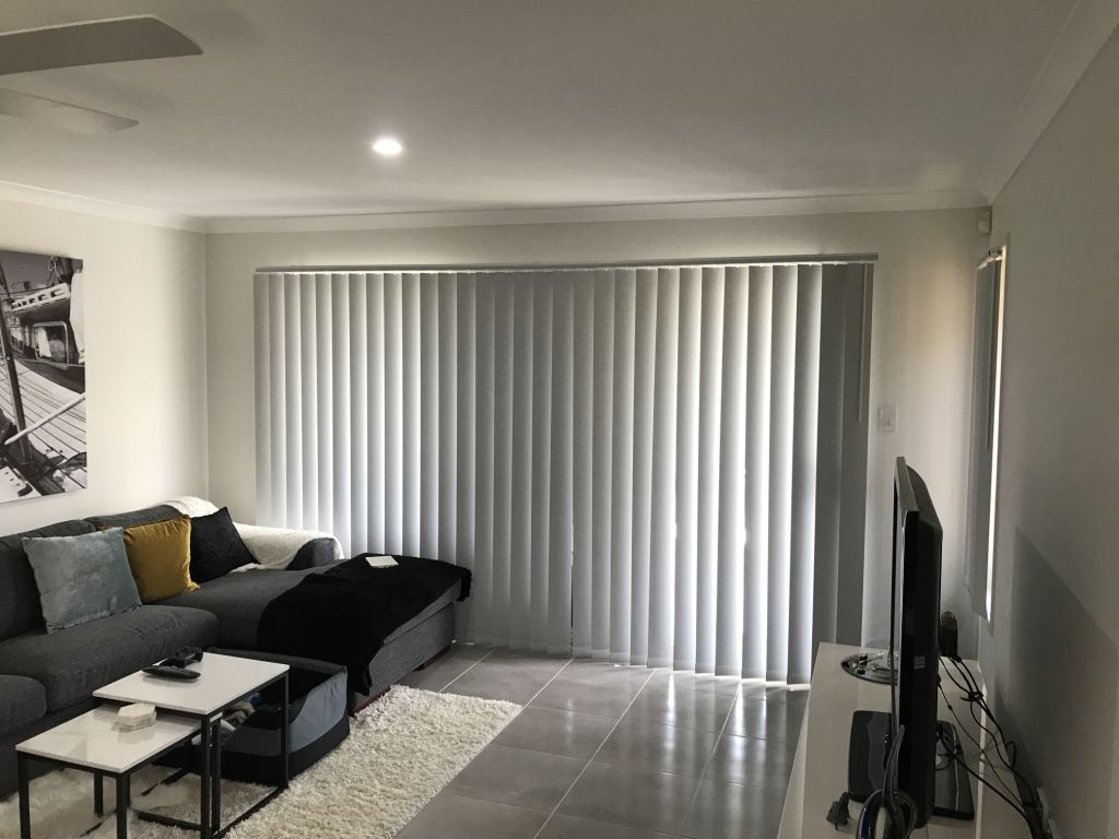 Contemporary kitchen and dining area in North Lakes featuring Crown Glide panel blinds for sleek, modern light control and privacy.