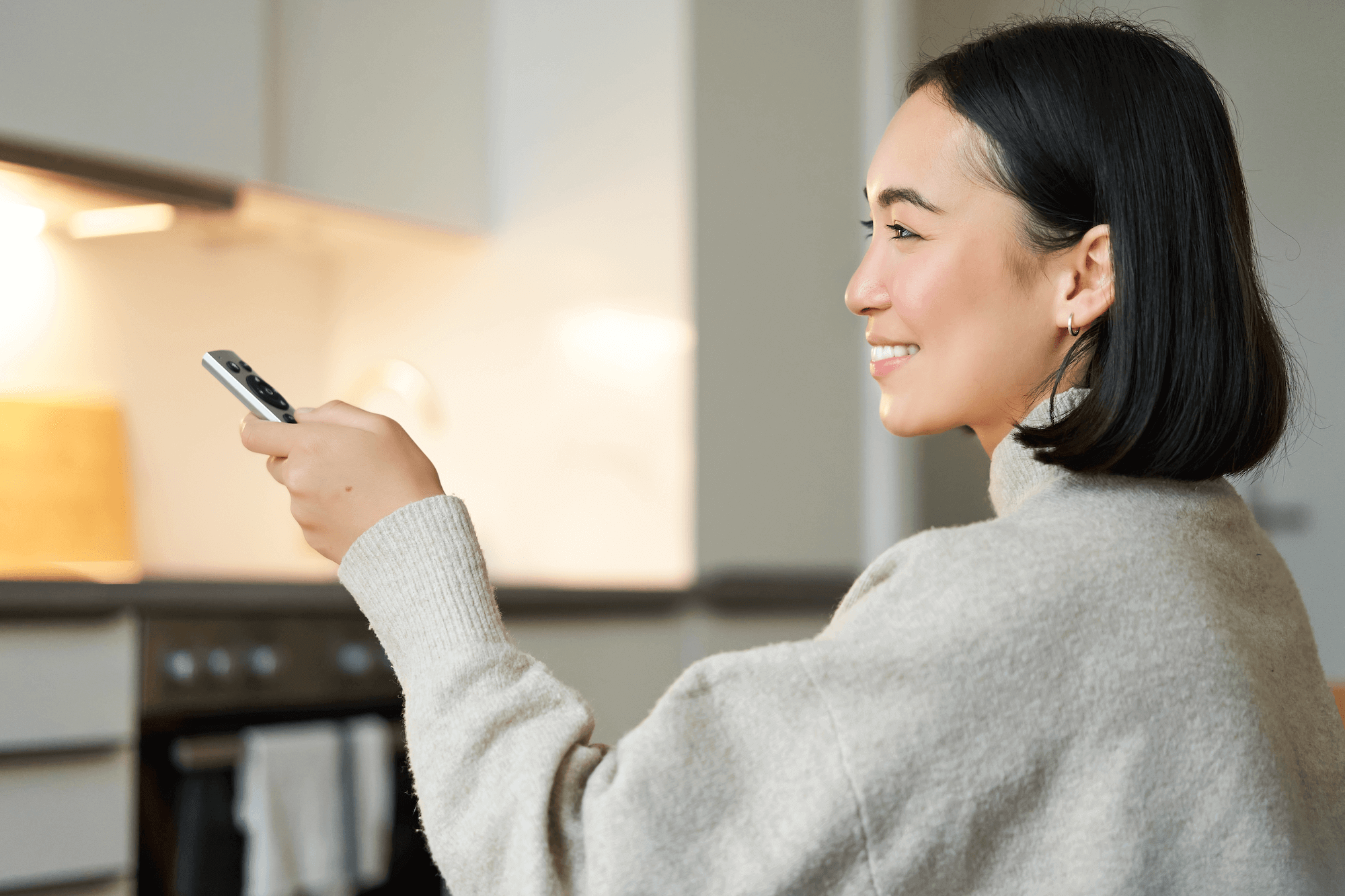 close-up-portrait-smiling-asian-woman-watching-television-sitting-sofa-with-remote-switching-chanel-looking-relaxed-resized White roman blinds in a living room area.